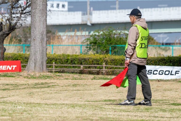 大会のコースで旗を持つスタッフ